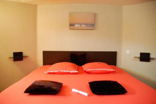 里昂桑切斯塔蒂亚娜旅馆的一张带橙色床单和枕头的床