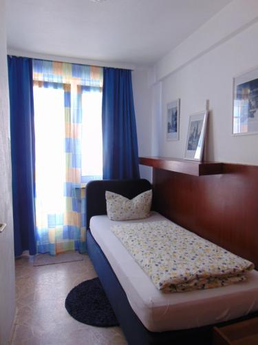 科隆Hostel Heinzelmännchen的一间卧室配有床和蓝色窗帘