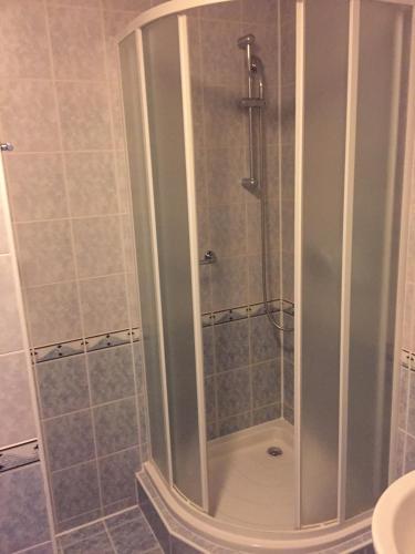 波普拉德塔特拉酒店的浴室里设有玻璃门淋浴