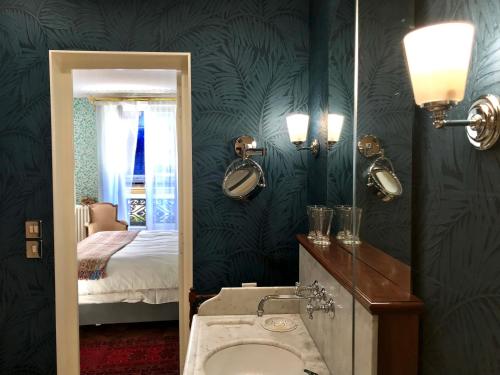 巴黎Le 48 Paris的一间带水槽和镜子的浴室以及一张床