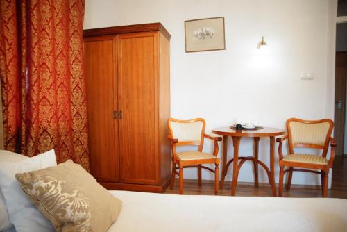 华沙文学馆旅馆的配有一张床和一张桌子及椅子的房间
