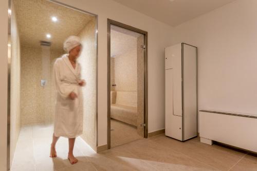 坎帕斯蒂利亚阿雷纳斯酒店的站在浴室里,穿着长袍的人