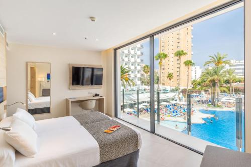 马盖鲁夫萨默斯酒店的一间卧室配有一张床,享有游泳池的景色