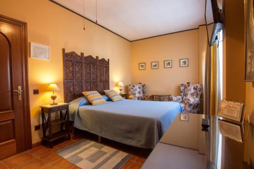 朗格勒Hosteria De Langre的一间卧室配有一张床和两把椅子
