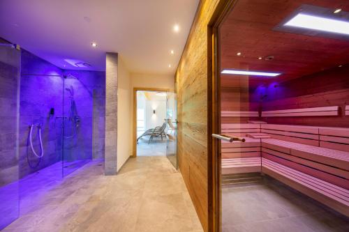 克里姆尔Hotel Post Krimml的浴室拥有紫色的墙壁和步入式淋浴间。