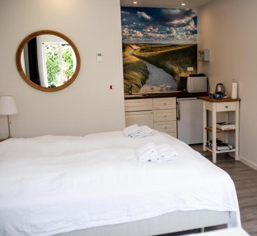 欧登塞恩格霍姆住宿加早餐旅馆的卧室配有白色的床和镜子
