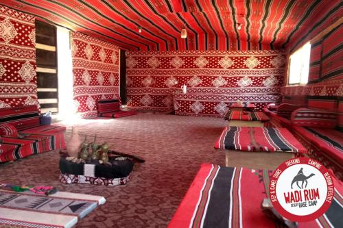 瓦迪拉姆Wadi Rum Desert Base Camp的一间设有红色墙壁的房间和一间带桌子的房间