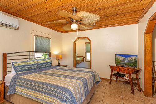 马里波萨河石旅馆的一间卧室配有一张带吊扇和一张桌子的床。