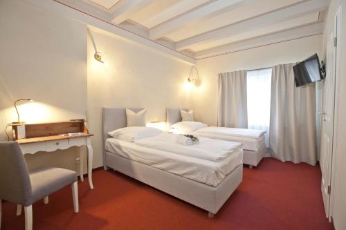路德斯塔德·威特比Altstadt Gästehaus的酒店客房,配有两张床和椅子