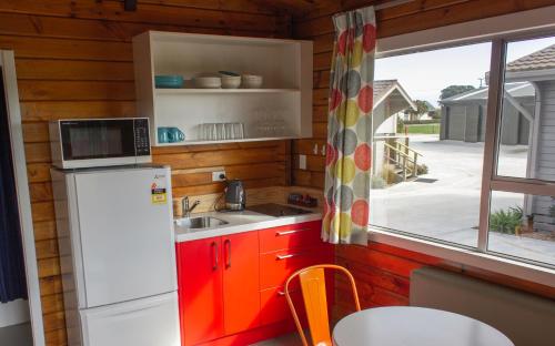Little WanganuiLittle Wanganui Hotel的厨房配有冰箱、水槽和窗户。