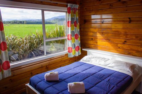 Little WanganuiLittle Wanganui Hotel的一间卧室设有蓝色的床和大窗户