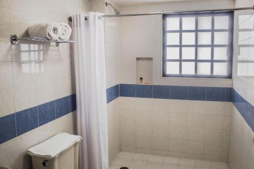 韦拉克鲁斯Múcara hotel的带淋浴和卫生间的浴室以及窗户。