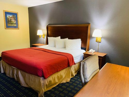 盖恩斯维尔盖恩斯维尔优值汽车旅馆的酒店客房,配有一张带红色毯子的床