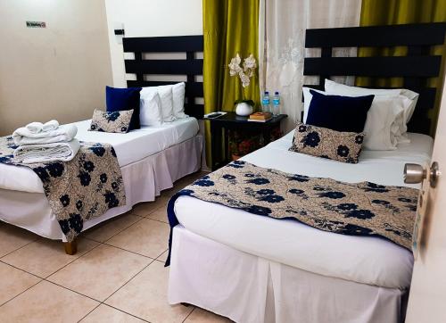 金斯敦新金斯顿住宿加早餐旅馆的蓝色和白色的酒店客房内的两张床