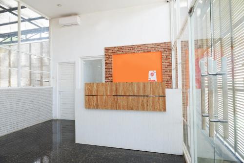三宝垄Super OYO 1250 Unta Residence的走廊上设有砖墙,墙上挂着橙色画