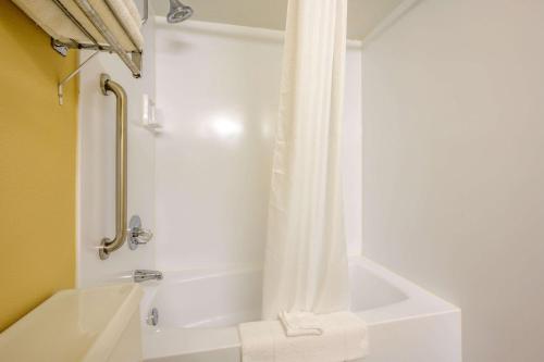 Triadelphia特瑞阿德尔福亚伊克诺套房旅店的浴室配有浴缸和淋浴及浴帘