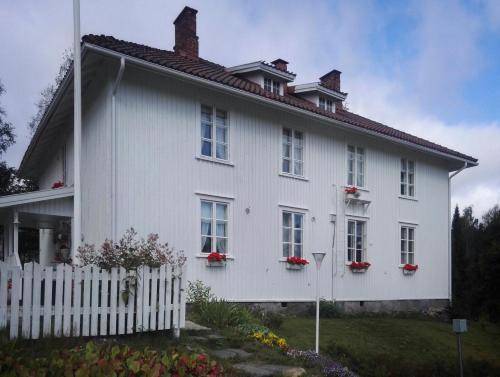 OutokumpuKyykerin Kartano的白色房子,窗户上装有红色的鲜花