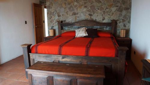 San Antonio Palopó阿提兰别墅旅馆的一间卧室配有一张带红色棉被的木床