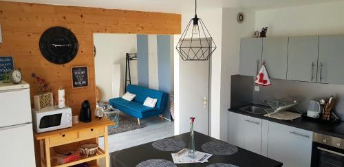 热拉梅Appartement 50m du Lac的一间厨房,在房间内配有蓝色沙发