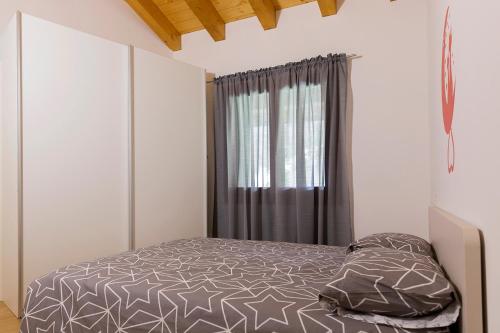 PolcenigoAppartamento Sonelia的一间卧室设有一张床和一个窗口