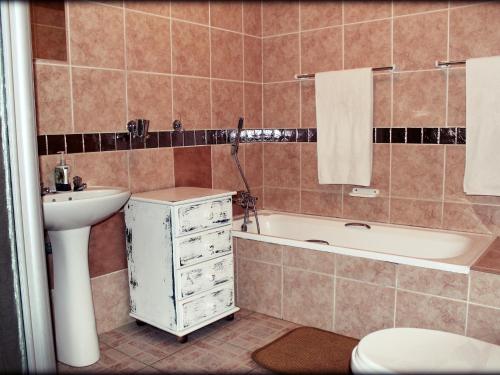 莱登堡阿夸特拉宾馆的一间带水槽、浴缸和卫生间的浴室