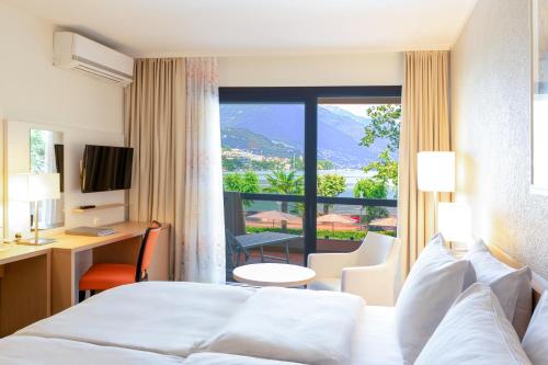 洛迦诺阿卡迪亚洛迦诺H4酒店的酒店客房设有一张床和一个大窗户