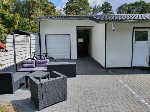 柯尼希斯武斯特豪森Monteurzimmer Senzig的房屋设有带紫色家具的庭院和车库