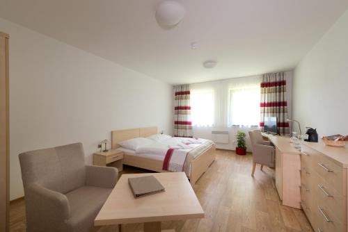 利帕河畔卡梅尼采约翰卡度假酒店的一间卧室配有一张床、一张桌子和一张桌子