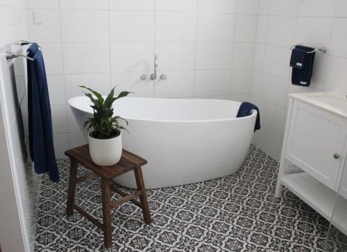 达博内陆酒窖乡村民宿的浴室设有白色浴缸和盆栽植物
