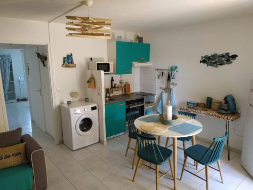 托尔雷莱Résidence Village Marin Catalan TORREILLES PLAGE的厨房配有桌椅和洗衣机。