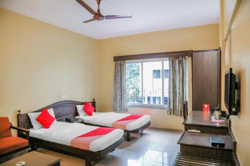 浦那Hotel Nandanvan Annexe的酒店客房设有两张床和窗户。
