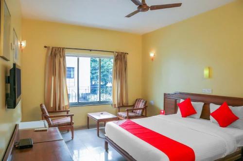 浦那Hotel Nandanvan Annexe的一间卧室配有一张床、一张书桌和一个窗户。