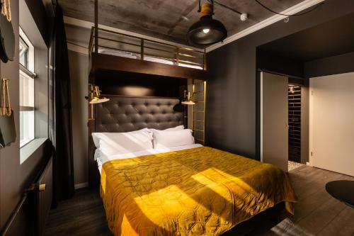 雷克雅未克R13 - A Townhouse Hotel的一间卧室配有一张黄色床罩的床