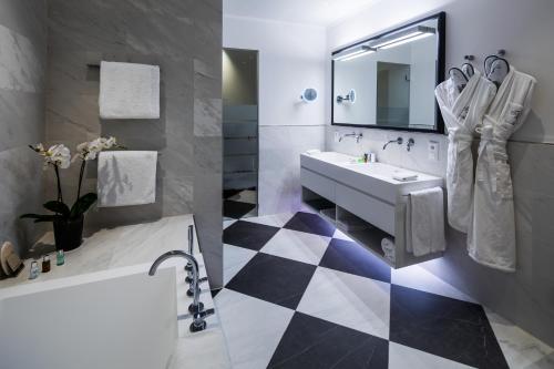 慕尼黑慕尼黑皇宫酒店的浴室铺有黑白格子地板。