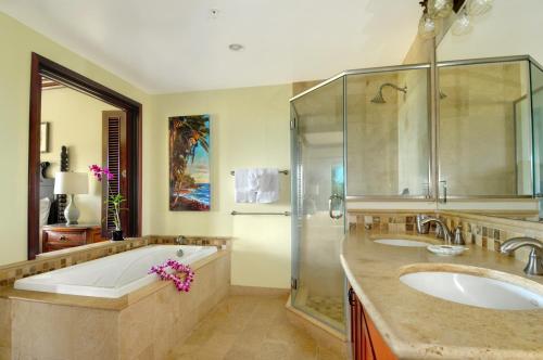卡帕阿Waipouli Beach Resort Penthouse Exquisite Ocean & Pool View Condo!的浴室配有2个盥洗盆、浴缸和淋浴。