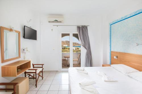迈洛波塔斯马科斯海滩酒店的一间卧室配有一张床、一张书桌和一面镜子