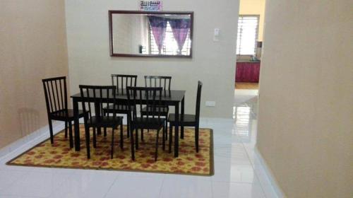 甲抛峇底Nurul Homestay的一间位于地毯上的带桌椅的用餐室