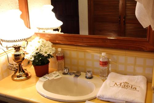 瓦哈卡市Hotel Maela的浴室水槽设有两盏灯和一面镜子