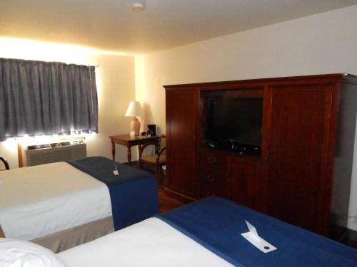 苏圣玛丽Americas Best Value Inn Sault Ste. Marie的酒店客房设有两张床和一台平面电视。