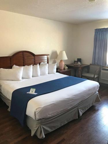苏圣玛丽Americas Best Value Inn Sault Ste. Marie的一间卧室配有一张带蓝色毯子的大床