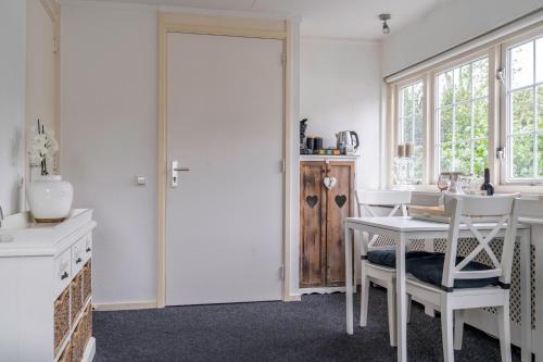 阿珀尔多伦CENTRUM-MARIASTRAAT-APELDOORN的白色的厨房配有桌椅和门