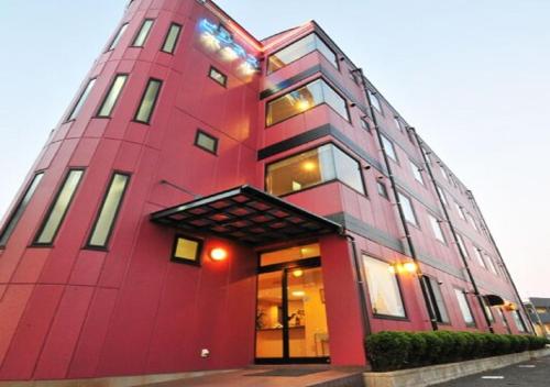 大村市Omura - Hotel / Vacation STAY 46228的一座高大的红色建筑,设有窗户
