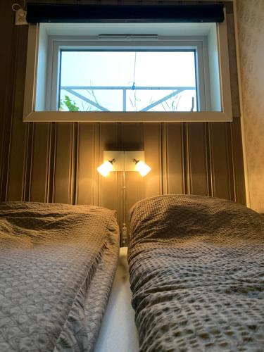 莱克内斯Cozy & private room in the middle of Lofoten的一间卧室设有两张床和窗户。