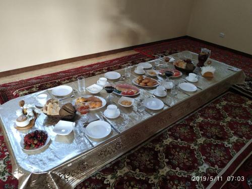 希瓦Xurshidabonu Guest House的餐桌上放有盘子和碗的食物
