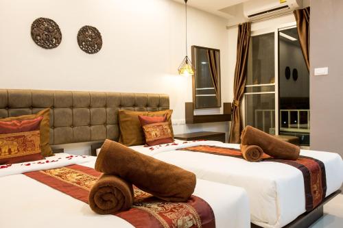 莱卡邦Pongsakorn Boutique Resort -SHA Extra Plus的两张位于酒店客房的床,配有毛巾