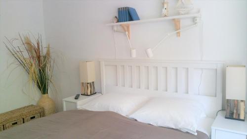 柏林HOLI DAY SPA Appartement 1的一间卧室配有白色墙壁和架子。