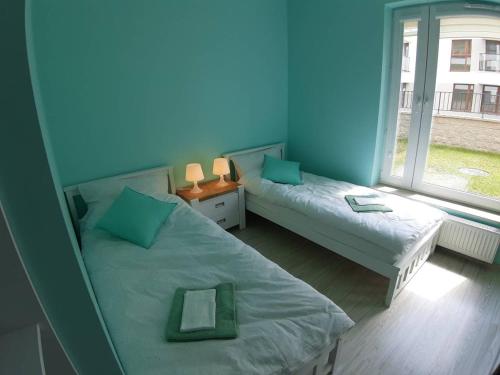 卢布林Apartament Cyrkoniowa的一间卧室设有两张床和大窗户