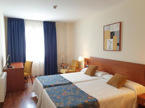 特鲁埃尔卡马伦纳套房酒店的一间酒店客房,房间内设有两张床
