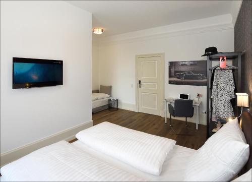 巴特恩豪森City Hotel ApartM3 am Park的一间卧室配有一张床,墙上配有电视