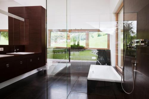 东蒂罗尔地区马特赖Designhaus COOP的带浴缸、水槽和窗户的浴室